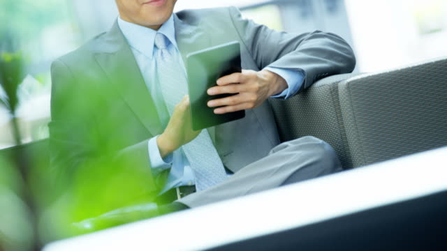Portrait-Asian-Chinese-businessman-using-office-wireless-tablet