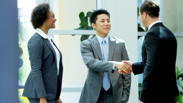 Male-female-multi-ethnic-real-estate-team-handshake