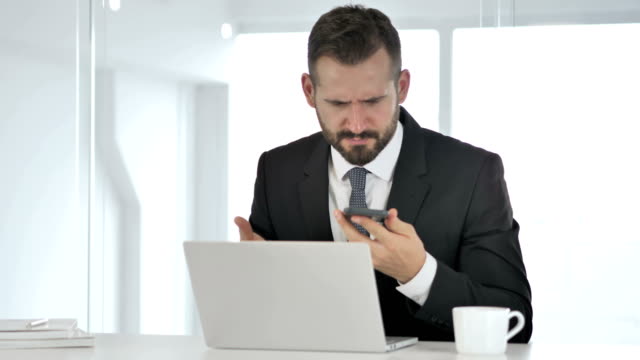 Angry-Businessman-Yelling-on-Phone,-Financial-Loss