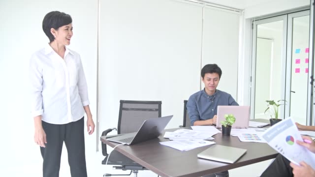 Business-meeting.-Small-start-up-business-meeting-in-room.-Asian-team-with-man-and-woman-accepting-and-agree-on-ideas-and-clapping.-New-business-model-start-up-concepts.