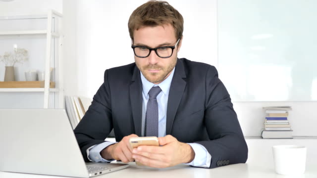 Businessman-Using-Smartphone-at-Work