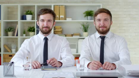 Porträt-von-männlichen-Zwillingen-im-Büro-arbeiten