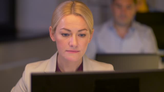 businesswoman-at-computer-working-at-night-office