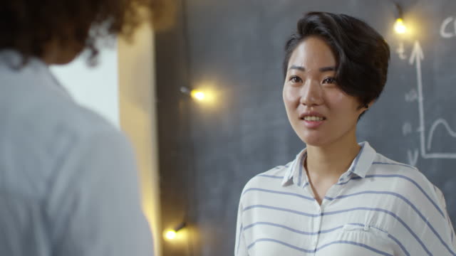 Young-Asian-Woman-Listening-to-Colleague