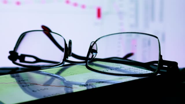 Online-Handel-Börsendaten-auf-einen-Monitor-und-Brille.