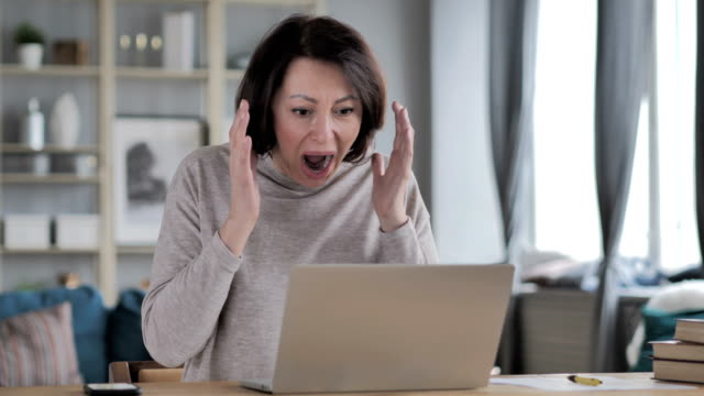Shocked,-Stunned-Old-Senior-Woman-Wondering-and-Working-on-Laptop