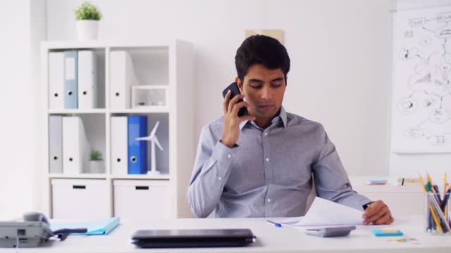 businessman-calling-on-smartphone-at-office