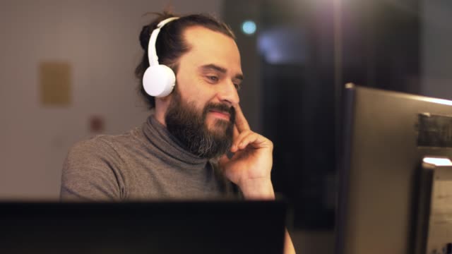 kreative-Menschen-mit-Kopfhörern-arbeiten-im-Büro