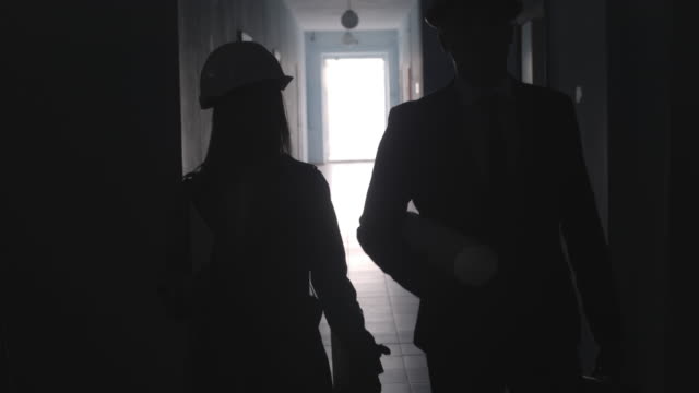 Silhouettes-of-Architects-Going-Together-along-Hallway