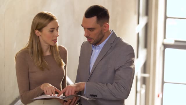 businesswoman-and-businessman-discussing-documents