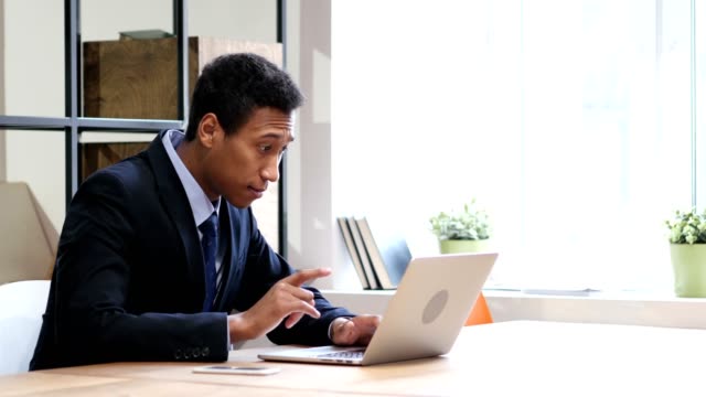 Black-Businessman-Celebrating-Success-while-Working-on-Laptop