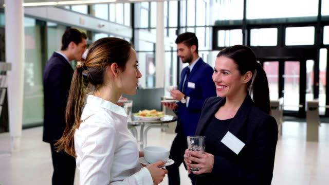 Smiling-businesspeople-interacting-with-each-other-during-break