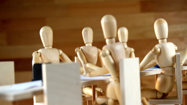 Wooden-figurines-having-meeting-in-conference-room
