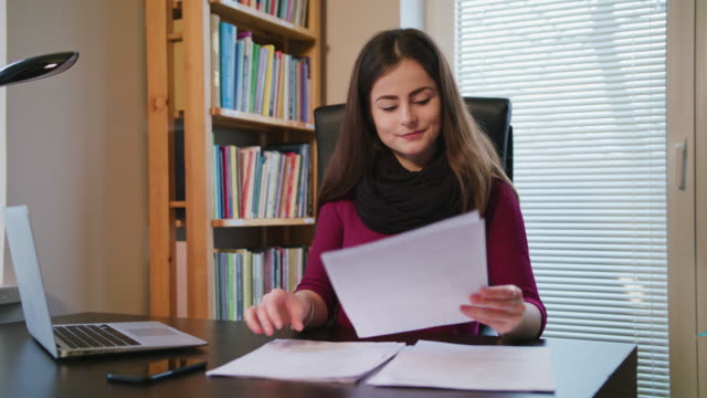 Cheerful-Young-Woman-Looking-on-Documents
