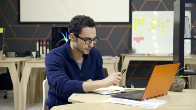 Kreative-Menschen-in-Gläsern-mit-Laptop-am-Arbeitsplatz