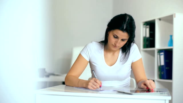 Beautiful-young-woman-writing-something-in-her-notepad