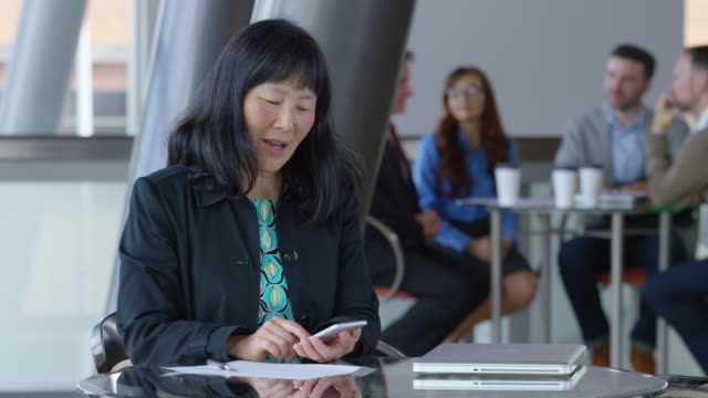 Mature-Asian-businesswoman-using-phone