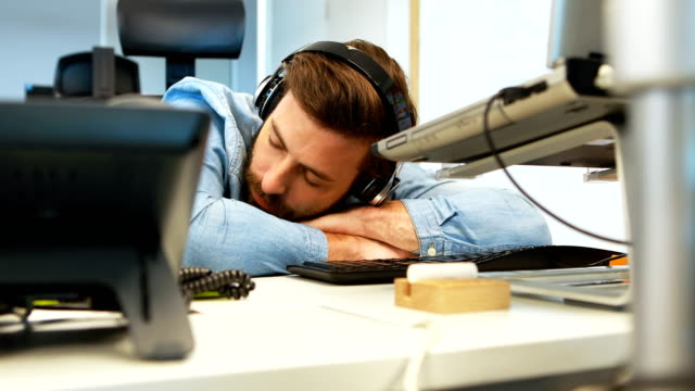 Diseñador-gráfico-hombre-durmiendo-en-el-escritorio