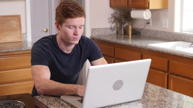 Junger-Mann,-arbeiten-am-Computer-in-Küche