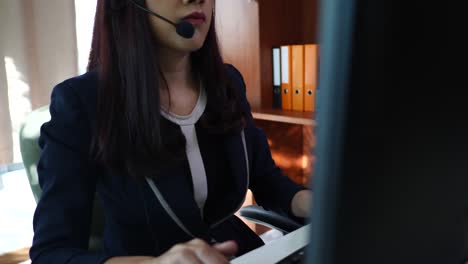 Geschäftsfrau,-die-durch-den-Computer-in-Kopfhörer-im-Büro-sitzen.-Call-center