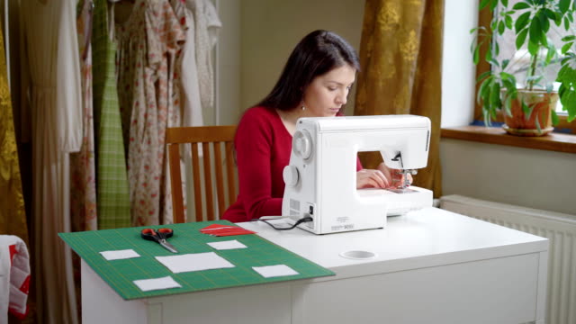 Hermosa-mujer-morena-es-ajustar-la-máquina-de-coser