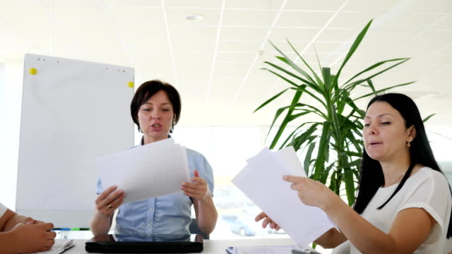 Konzernleitung-mit-Papierbögen-vertreibt-Zuweisungen-für-Kollegen-in-weißen-Büro