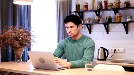 Amazed,-Happy-Young-Man-Working-on-Laptop-in-Kitchen