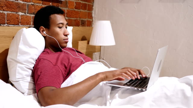 Video-Chat-para-trabajo-por-África-joven-tumbado-en-la-cama-por-la-noche