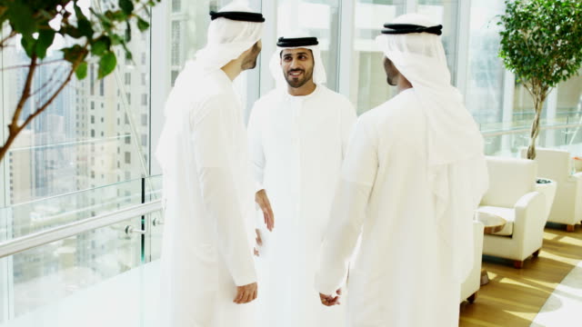 Dubai-Arabische-Geschäftsleute-in-Nationaltracht-treffen-Innenstadt
