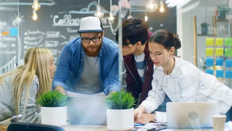 Diverse-Team-of-Young-Women-and-Men-Developers-Have-Team-Meeting-Using-Laptop.-Beautiful-Young-People-in-Bright-Modern-Office-Environment.