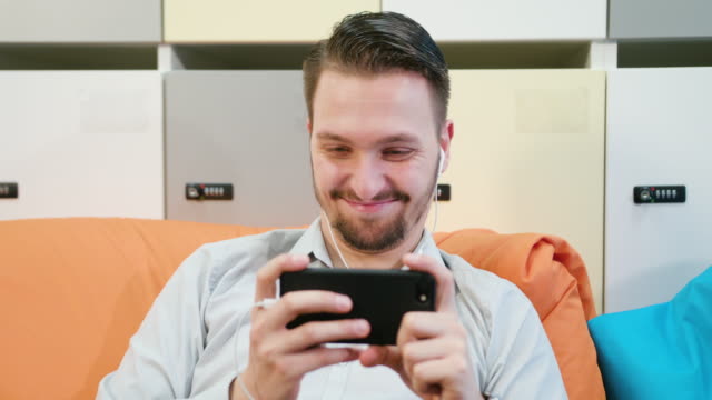 Man-Watching-Videos-on-the-Smartphone-Indoors