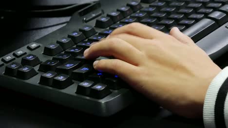 Hände-des-Mannes-auf-eine-Gaming-Tastatur-spielen.