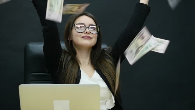 Beautiful-young-businesswoman-is-counting-money,-fanning-herself-with-dollars,-laughing-and-throwing-them-in-the-air
