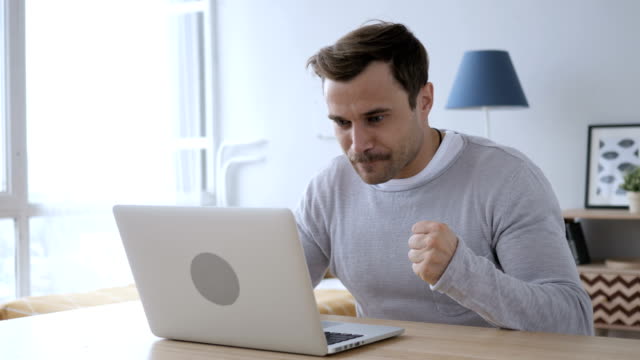 Adult-Man-Celebrating-Success,-Working-on-Laptop