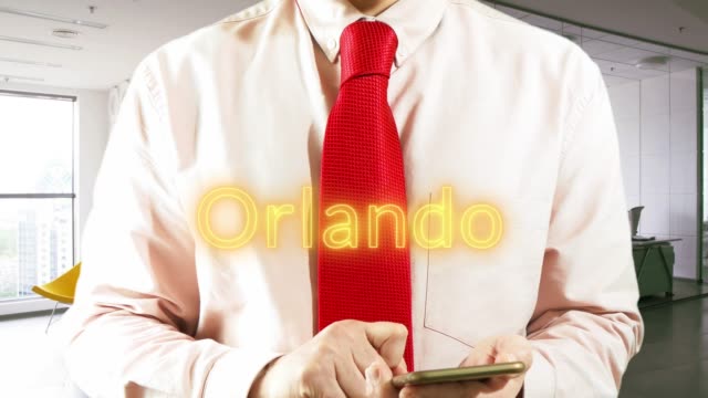 ORLANDO-Geschäftsmann-Betrieb-ein-intelligentes-Gerät-wählt-а-Stadt-auf-hellem-Hintergrund