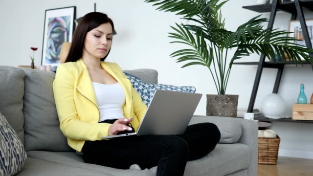 Young-Woman-Working-On-Laptop,-Sittting-on-Sofa-in-Office