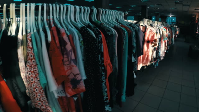 Rows-with-clothes-on-hangers-hang-in-the-second-hand-shop.-View-inside-the-shopping-center
