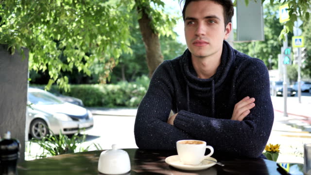 Young-Man-Sitting-in-Cafe-Terrace