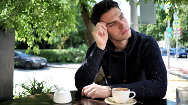 Thinking-Young-Man-Sitting-in-Cafe-Terrace