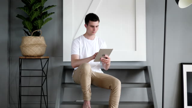 Mann-sitzt-auf-der-Treppe-Browsing-und-Scrollen-auf-Tablet