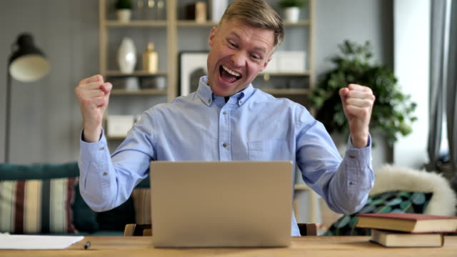 Excited-Businessman-Celebrating-Success,-Working-on-Laptop