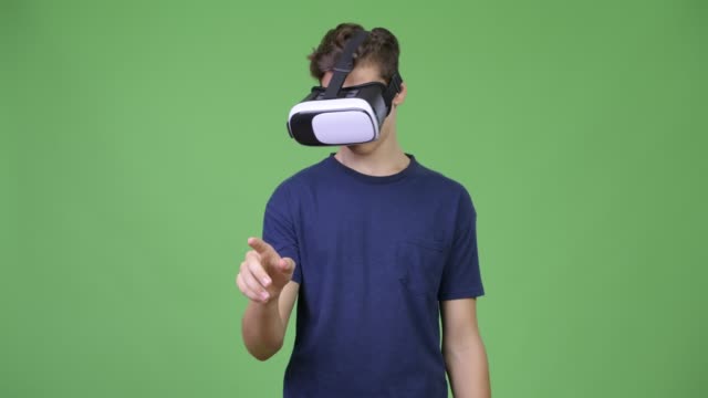 Young-handsome-teenage-boy-using-virtual-reality-headset