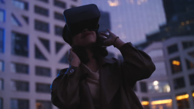 lenta-de-una-mujer-bastante-joven-asiático-con-VR,-casco-de-realidad-virtual-al-aire-libre-en-el-parque-de-la-ciudad
