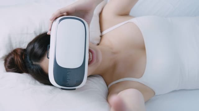 Frau,-die-gerade-virtual-Reality-Gerät-auf-Bett