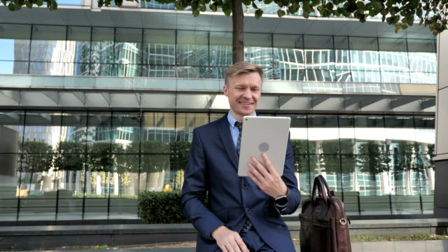 Online-Video-Chat-auf-Tablet-von-Geschäftsmann-im-Anzug
