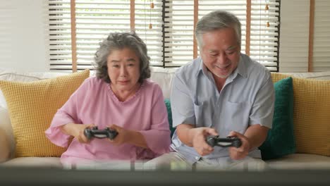 Pareja-senior-asiático-jugando-juego-juntos-en-casa-con-emoción-feliz.-Personas-con-relajación,-vejez,-jubilación,-concepto-de-familia-estilo-de-vida-superior.
