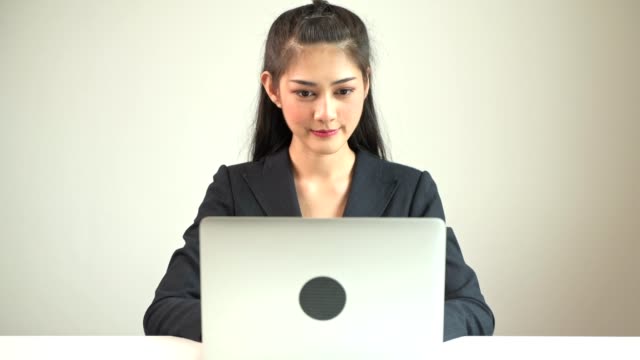 Mujer-de-negocios-escribiendo-en-la-laptop.-Mujer-de-negocios-asiática-hermosa-joven-en-juego-escribiendo-en-la-computadora-portátil-frente-a-cámara.