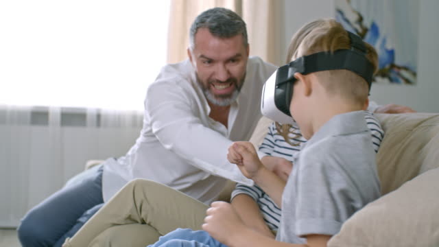 Parents-Watching-Son-Playing-VR-Game