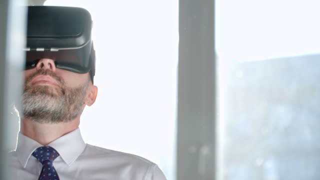 Businessman-in-VR-Goggles-Talking-on-Phone