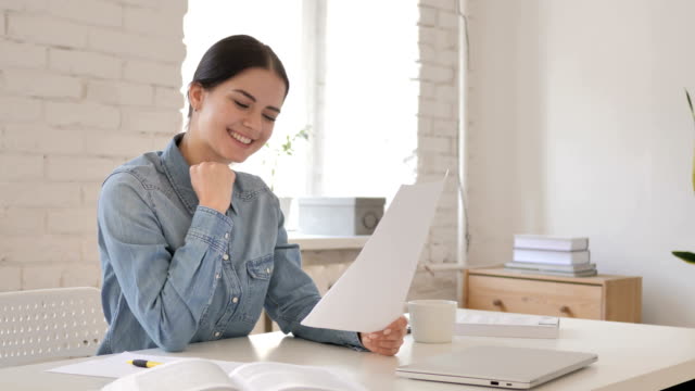Young-Girl-Reacting-to-Successful-Contract,-Reading-Documents